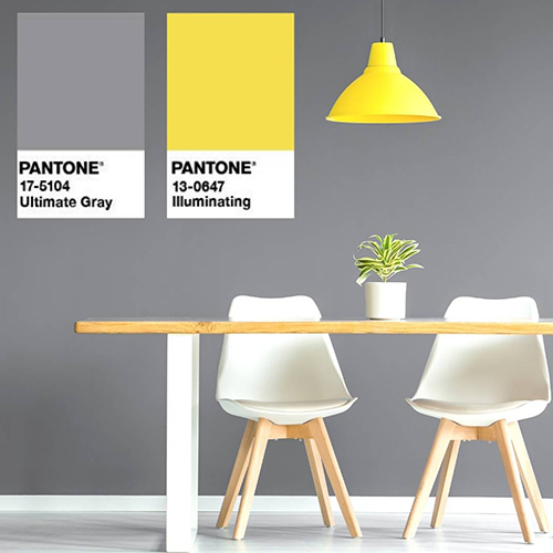 grey dining room ideas - grey dining area with yellow light fixing and yellowish wood table, with Pantone shade Ultimate Grey and Illuminating (a sunny yellow) overlaid