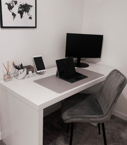 A grey stylish dining chair being used as an office chair