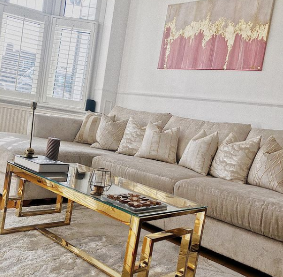 A velvet bench that has been converted into a glass top coffee table