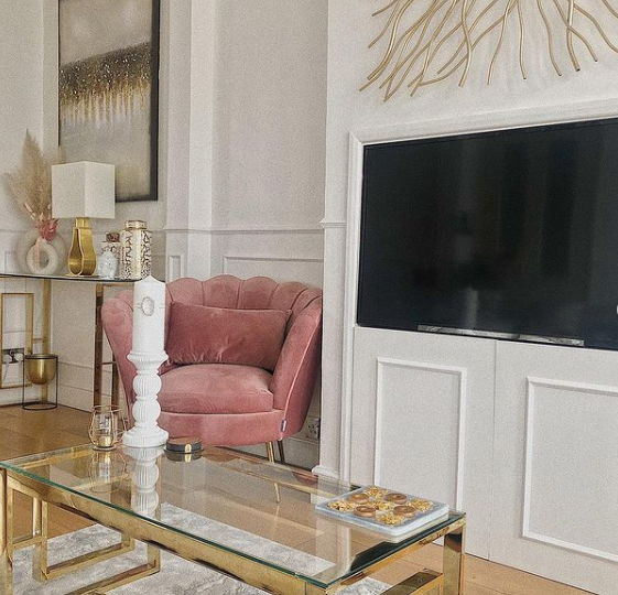 A stylish pink velvet chair used as additional seating in the living room