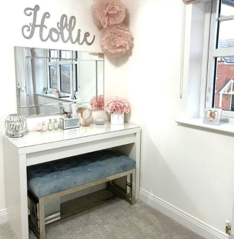 A velvet bench being used next to a dressing table