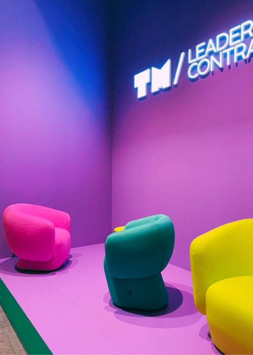 bright velvet accent chairs in pink, green and yellow against purple wall