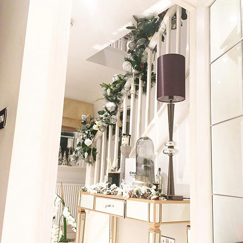hosting the perfect Christmas - IG image of hallway with christmas decoration garland n stairs and ecorated console table.