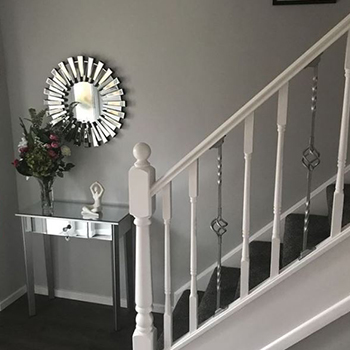 Hallway mirror ideas. Dark corenr at bottom of stairs. A mirrored console table and medium-sized round mirror in mirrored starburst frame have been placed here to reflect light from the front door. 