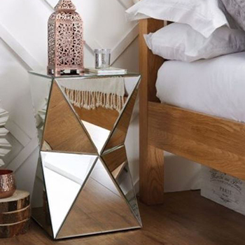Mirrored furniture ideas - geometic design mirrored bedside table beside pine bed. A morrocan style lantern sits on top, beside a glass of water and a book. The bedside table reflects the bed and linens. 