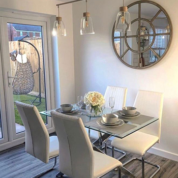 Window mirror ideas - Dining area with round mirror in the wall in a frame that makes it look like a window.