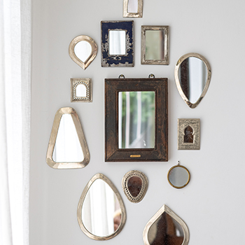 Gallery mirror wall ideas - a hallway with a collection of different mirrors all in different sizes, shapes and styles, hung together. 