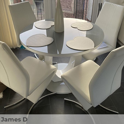 Customer image submitted by James D featuring modern dining area. Light walls and dark slate coloured floor tiles, with high gloss round dining table and 4 white faux leather dining chairs that have a zigzag shape. 