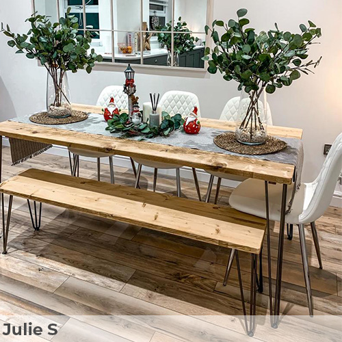 Customer image submitted by Julie S. Bright rustic-modern dining area. White wall with white window mirror, bare textured light wood floorbaords, and industrial style wood trestel table and bench with black metal angled legs. Also 4 white faux leather dining chairs with chrome legs. 