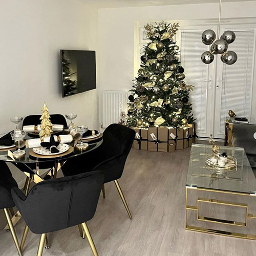 black and gold dining room with glass dining table and black velvet chairs