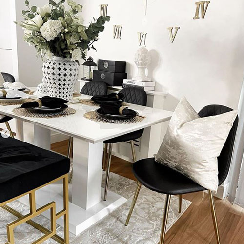 modern white gloss dining room with black and gold chairs