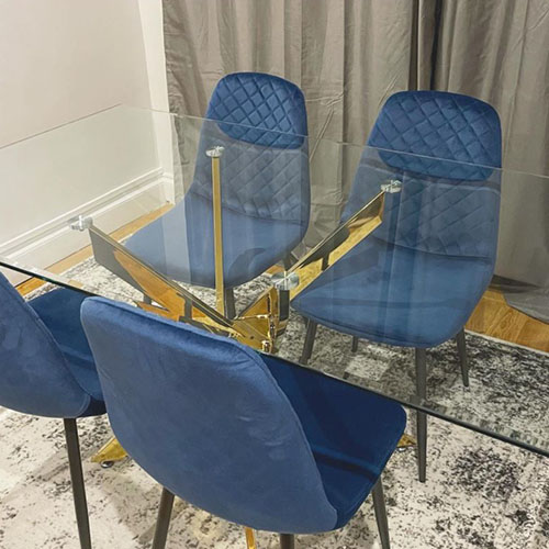 gold and glass dining table with navy velvet chairs