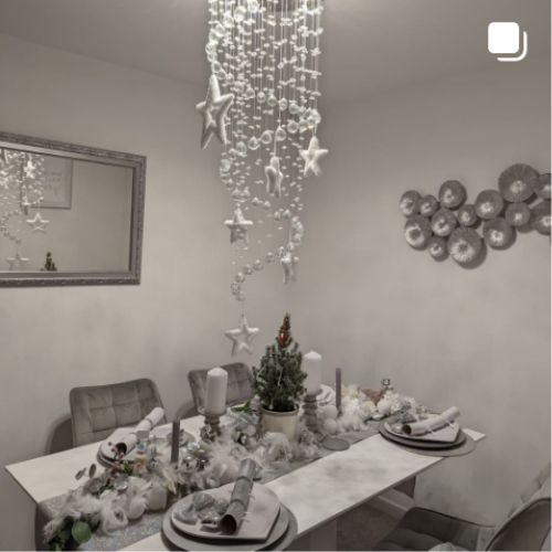 christams decor inspiration - grey dining room, white marble effect table with 4 grey velvet diing chairs, chrismtas decorations, star hanging mobile
