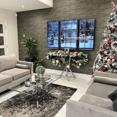 christmas decor inspiration for living room -  glass and chrome console table with matching coffee table, with christmas tree in candy cane theme