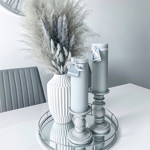 white gloss table with grey chairs and centrepieces on a tray