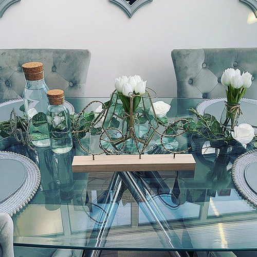 table garlend spelling Love in wicker letters and pale green leaves, with glass bottles and white flowers