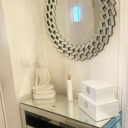 hallway featuring mirrored console table with large round wall mirror in mirrored frame