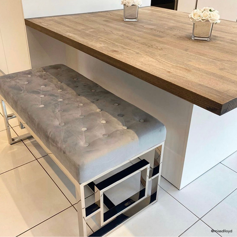 A chrome metal velvet bench used in a kitchen