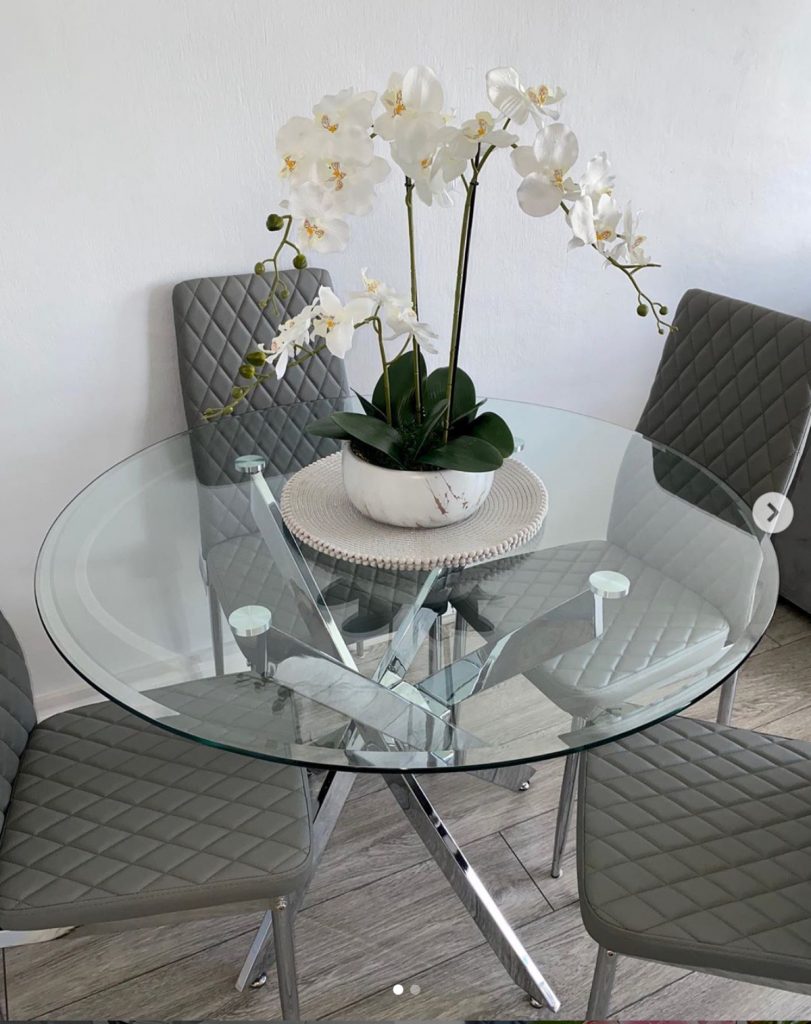 A round dining table with a glass top will give the impression of more space.