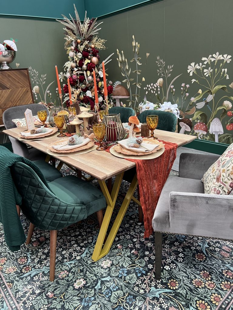 christmas dining room with woodland theme - wooden table, green velvet chairs, woodland tablescape in maximalist style