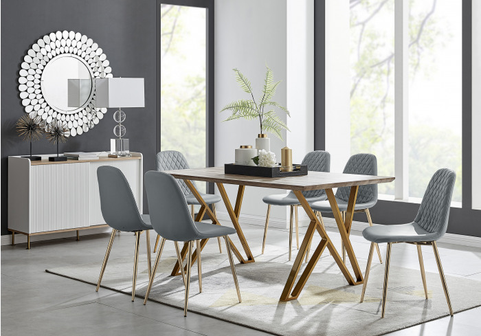 A wooden dining table and grey velvet dining chairs in a modern dining room with grey walls