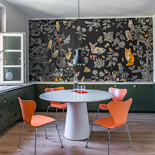 modern-retro dining area with dark floral wallpaper to one wall