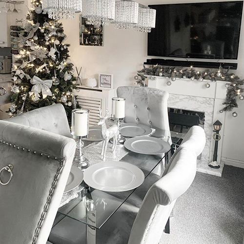 modern dining area with Christmas decorations around and on table.