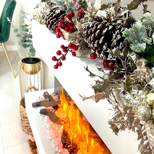 Instagram Christmas inspiration - fireplace with garland featuring pinecones, leaves, red berries and lights