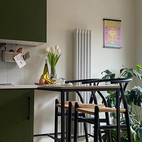 bright modern Industrial kitchen with wood and black metal br table and 2 bar seats.