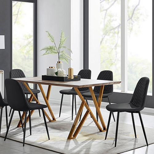 Wood effect trestle style table with gold geometric legs on either end. 6 black faux leather dining chairs with padded seats and diamond stitching, and black an gold accessories on the table. 