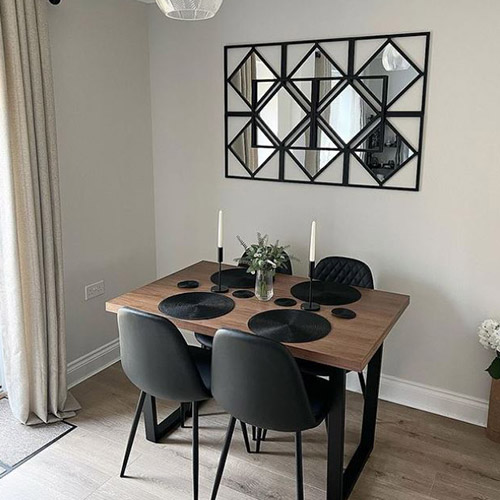 industrial dining table with thick wood effect tabletop and cunky black metal legs, with 4 faux leather black chairs with black tapered legs