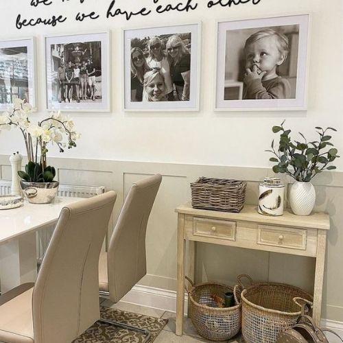 modern dining area with white hihg-gloss dining table and 4 faux leather chairs with cantilever legs, and rustic cream console table to one side, with 2 wicker storage baskets underneath. 