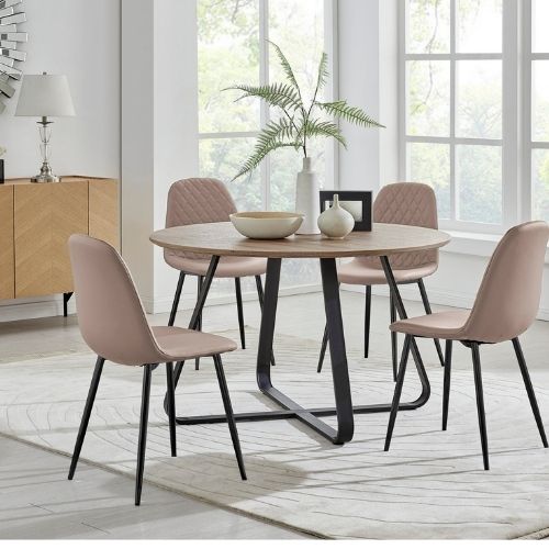 round wood effect table with black metal structural legs and 4 beige faux leather chairs with blck legs.