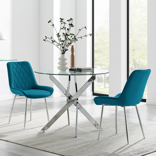 modern 2 seater dining table round glass table with silver chrome legs. 2 blue velvet chairs with silver legs.