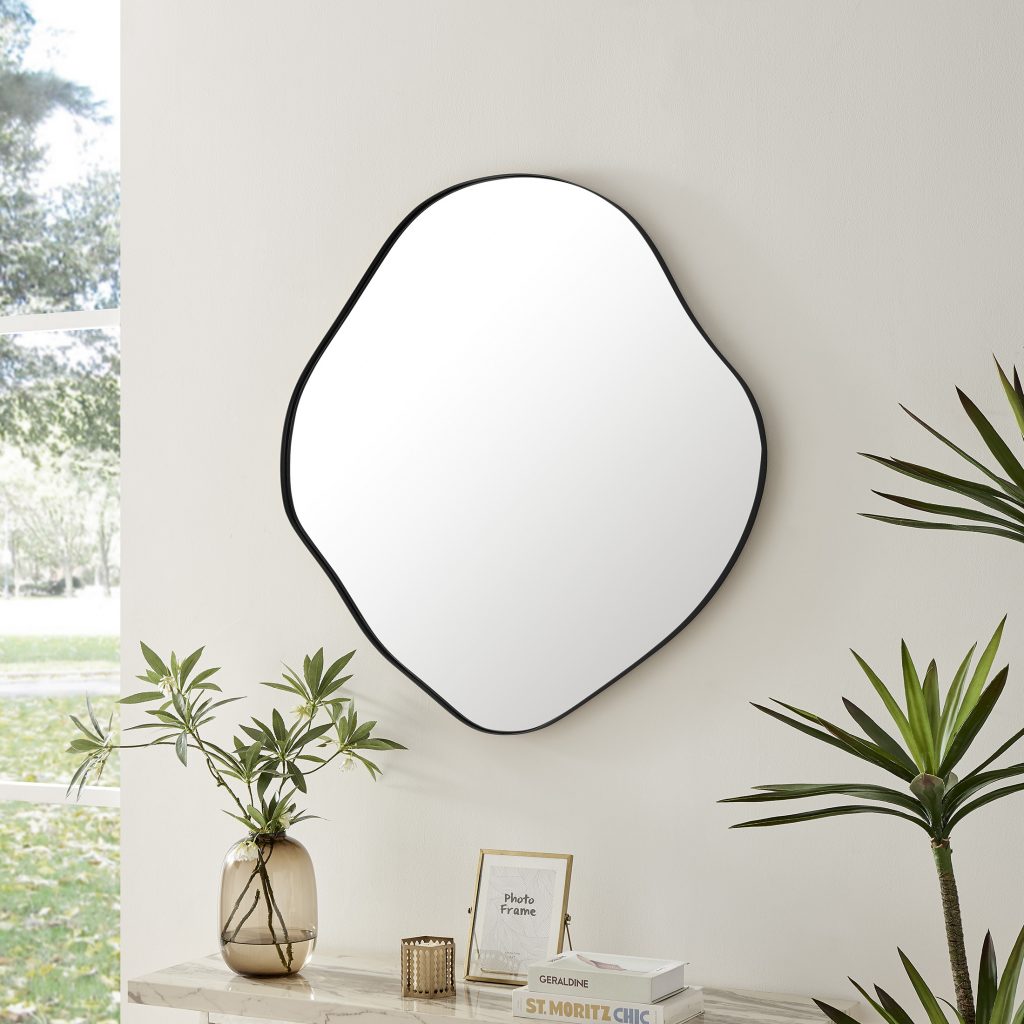 black framed wall mirror in organic puddle shape on neutral wall
