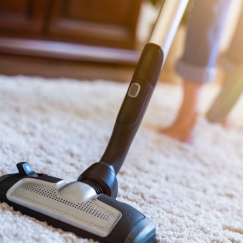 how to clean a rug easy to follow step image shows vacuum cleaning on rug