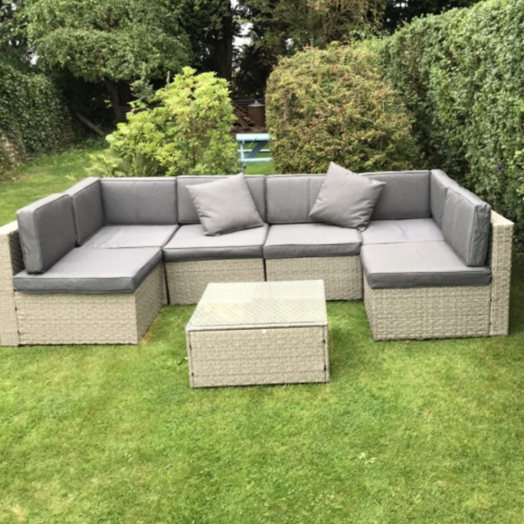 Beige outdoor garden set on lawn with grey cushions and coffee table