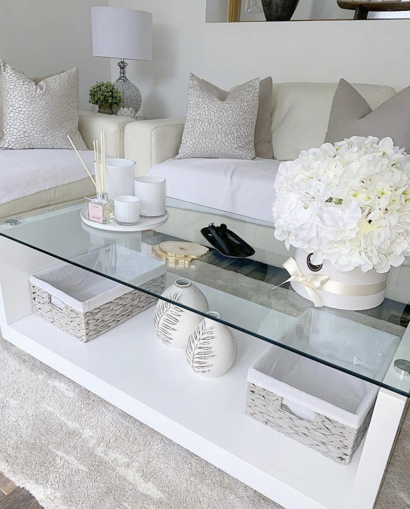 A white and cream living room space with a decorated coffee table