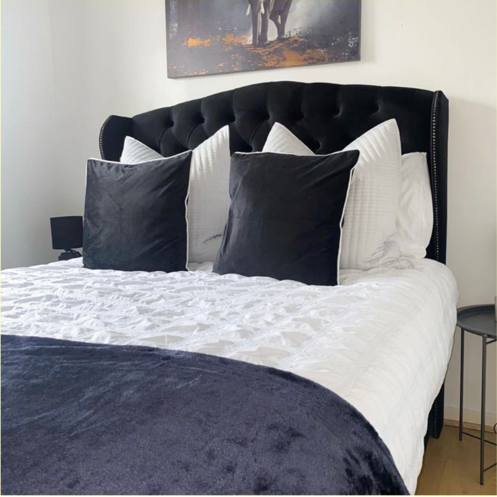 black and blue velvet bed styling with scatter pillows