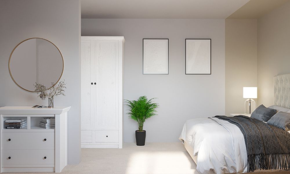 modern bedroom featuring a bed with tall button-tufted headboard, placed at 90 degress to a partition wall, where a round wall mirror is hung. The mirror cannot be seen from the bed.