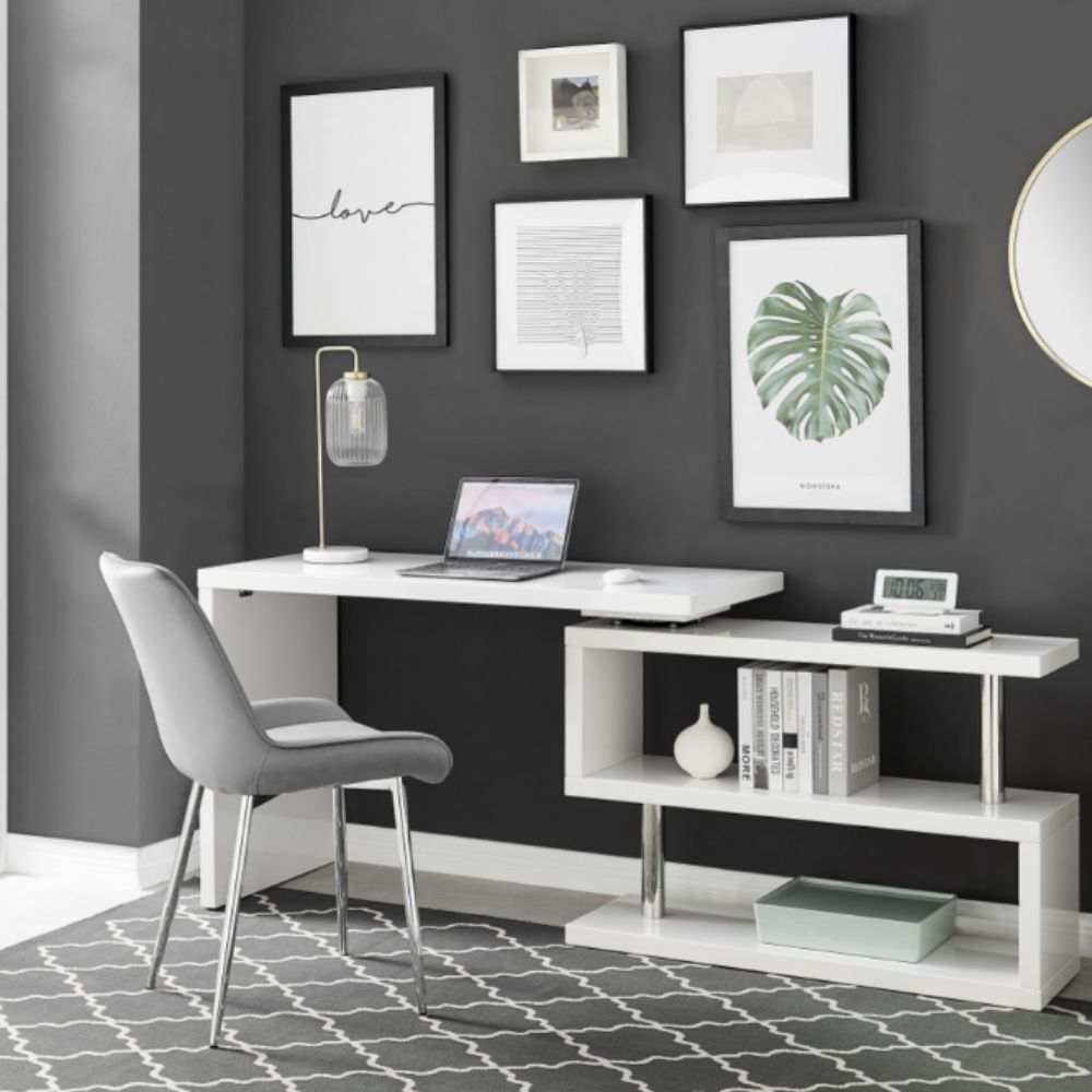 modern white high gloss rotating desk that is positioned with both desk and zig-zag shaped shelving flat against the wall. 