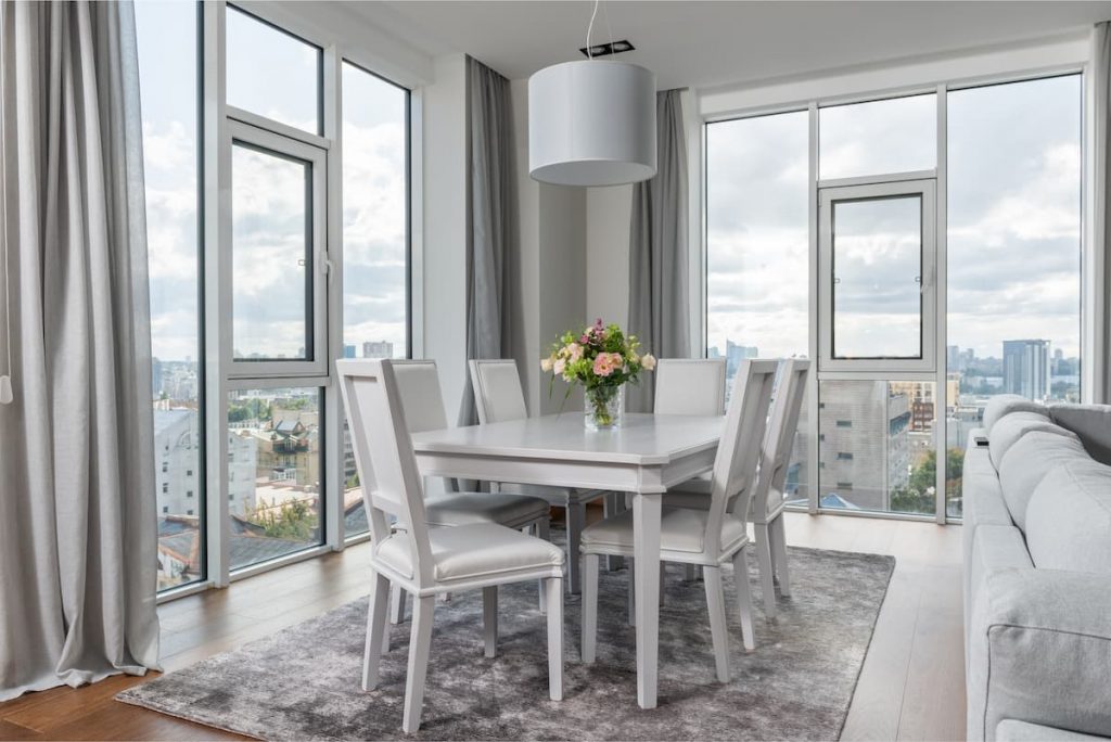 White dining chairs around a white dining table