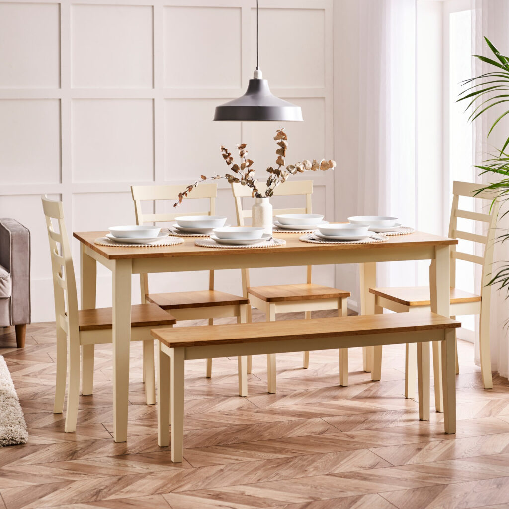 6 seat wooden dining table in cream paint and oak top, with matching cream and oak slat back dining chairs and 2 seat wooden bench rustic French farmhouse inspired dining room