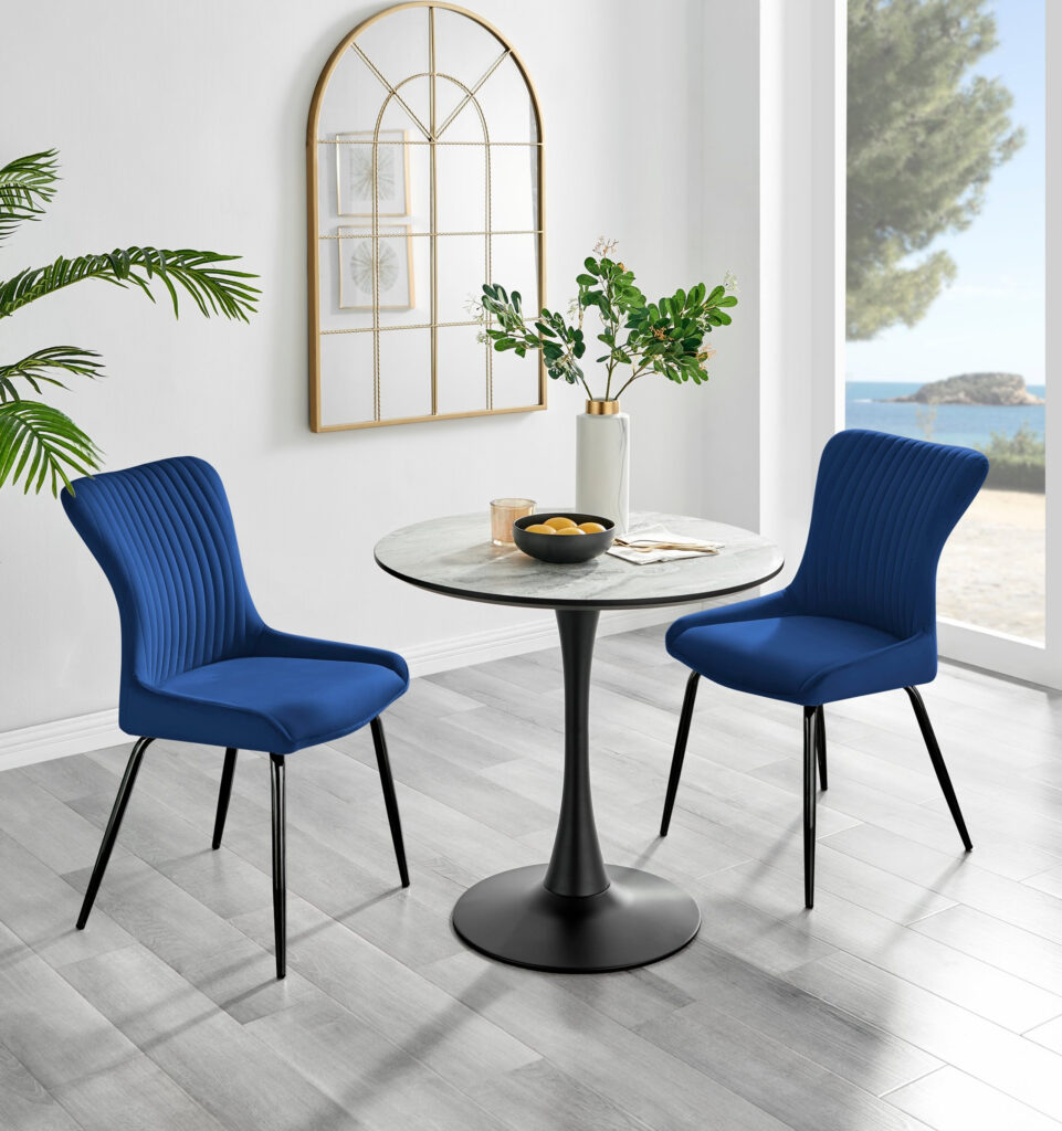 small round melamine top table with marble effect on black tapered Martinin glass stem leg, with 2 blue velvet dining chairs for chic Frnech inspired dining room