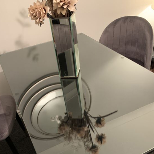 glass table top protector on dining table, with vase of flowers.