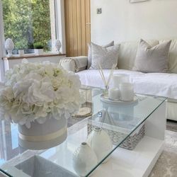 white and cream living room with white hihg gloss and glass coffee table and white roses