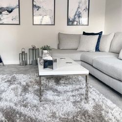 modern living room with white and grey decor, navy blue cushions and abstract wall art, with white high gloss and silver chrome coffee table
