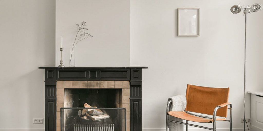 Alcove ideas furniture for alcoves blog banner image shows fireplace with modern retro chair, silver floor lamp and alcoves either side of fireplace