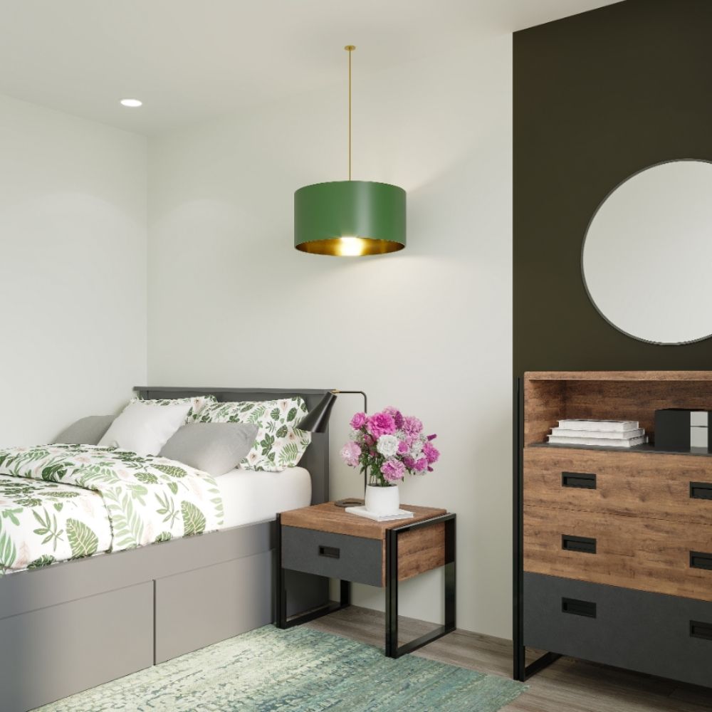 fresh and modern green and grey bedroom featuring grey solid pine bed with grey and leafy print linens, wood and grey furniture with black meta accents and sage green feature wall with round wall mirror