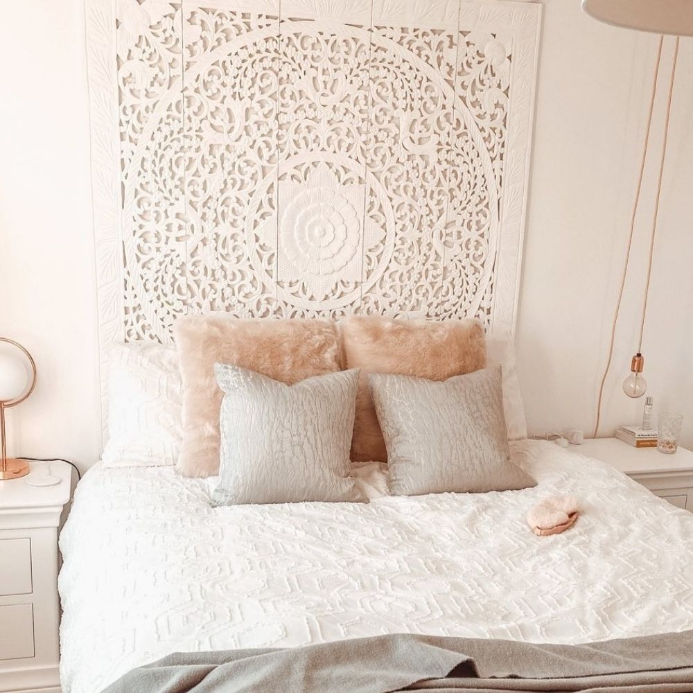 white and cream shabby chic boho style bedroom featuring white pine bed, with white fabrc mandala on wall